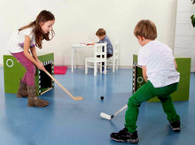 Carica l'immagine nel visualizzatore di Gallery, Kinder spielen Hockey mit der talentkiste, einem vielseitigen Holzspielmöbel für Bewegung, Motorik und aktives Spielen im Kinderzimmer.